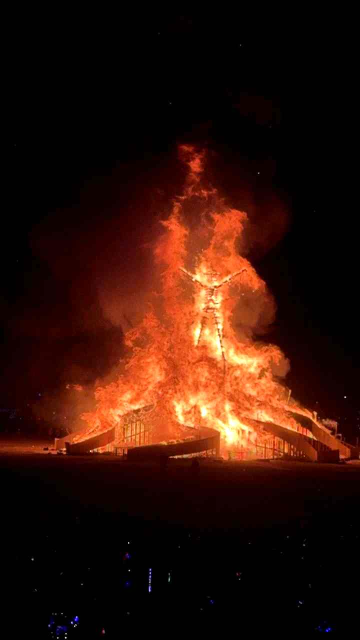 Burning Man structure on fire at night